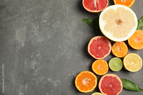 Different citrus fruits on grey background, top view. Space for text © New Africa