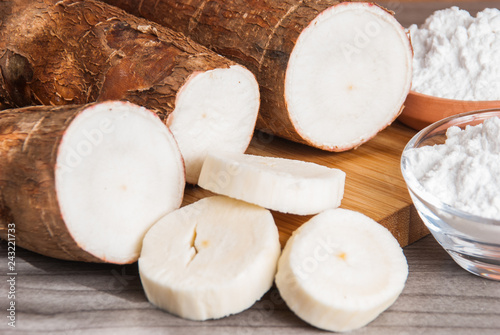 Raw cassava tuber on wooden background - Manihot esculenta photo