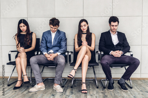 Group of business people sitting on chair waiting for job interview against wall background