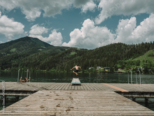 Rear view of shirtless boy diving in lake