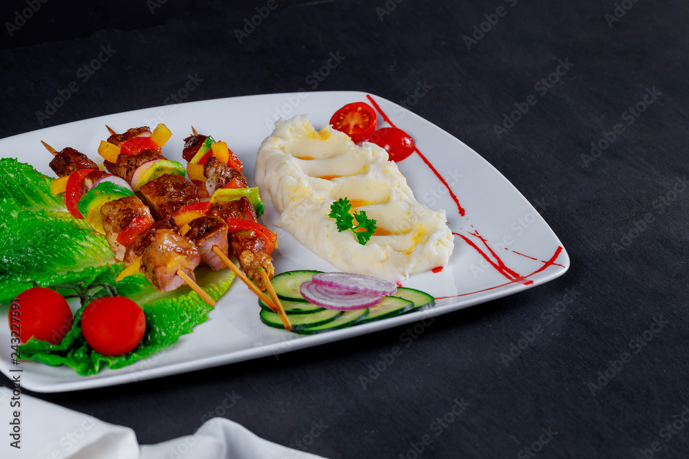 Pork skewers served with mashed potato Pork skewers served with mashed potato