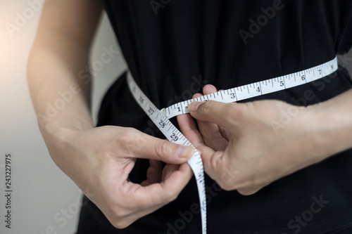 Diet concept close up women measuring waist circumference. photo