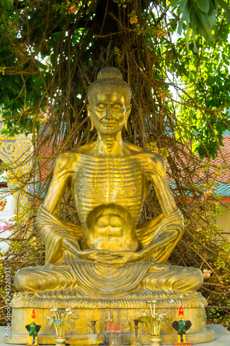 Fasting, emaciated, Golden buddha statue in Thai temple.