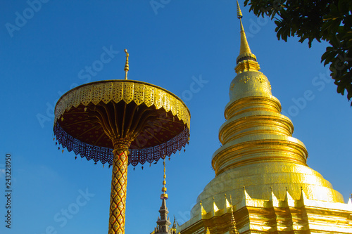 Golden pagoda and the golden umbrella with blue sky background.