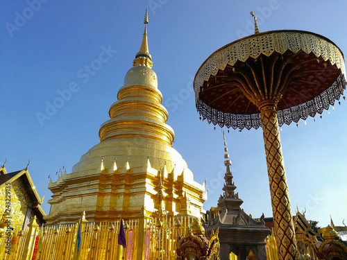 Golden pagoda and the golden umbrella with blue sky background.