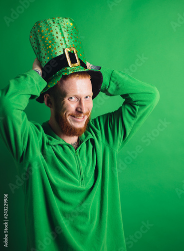 Lucky charms on green background. Man on green background celebrate St Patricks Day. Man in Patrick's suit smiling. photo