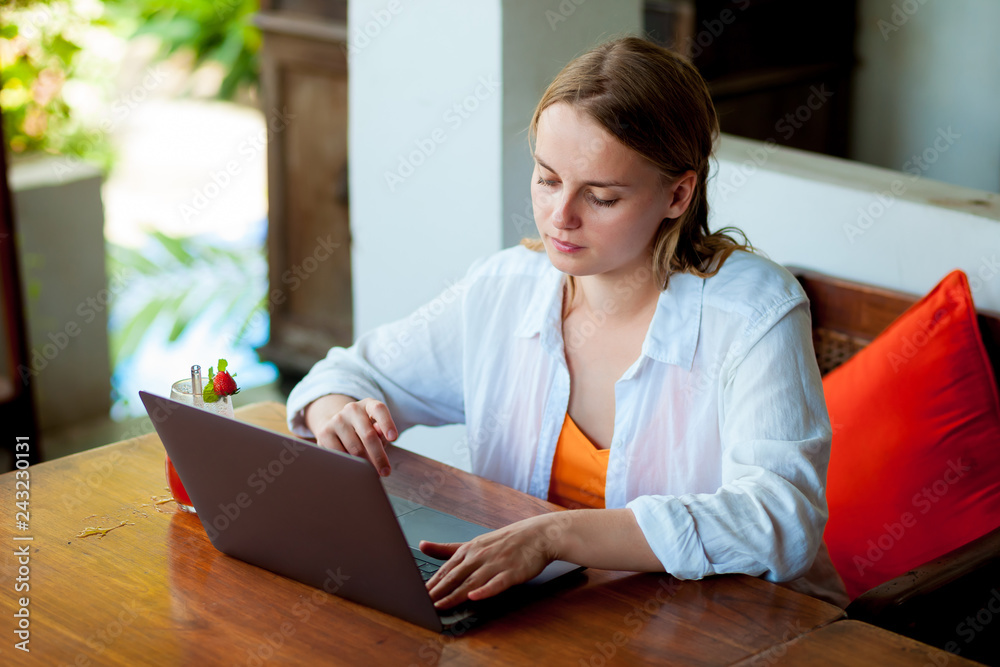 Girl freelancer working on a laptop in a cafe Girl freelancer working on a laptop in a cafe