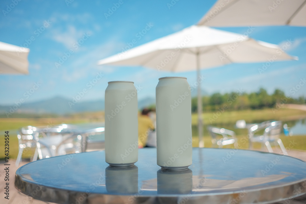 Fototapeta premium Beer cans on the table Parasols and natural views