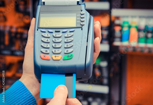 Using payment terminal for paying credit card in shop, finance and banking concept