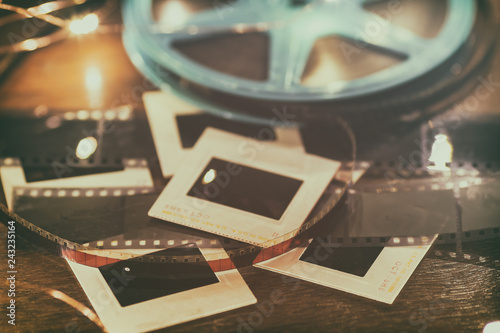 Photo slides, film negatives and 8mm or super 8 vintage film reel on a wood table with soft lights. photo