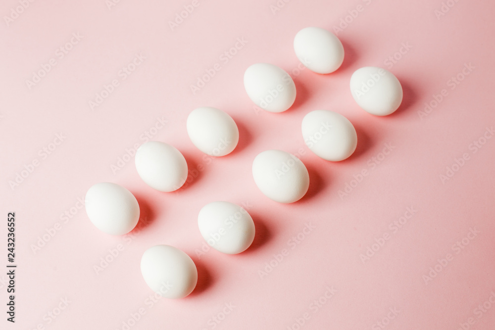 White eggs on a light pink background with reflection of the shadows and copy space. layout to easter. Flat lay, pattern White eggs on a light pink background with reflection of the shadows and copy space. layout to easter. Flat lay, pattern