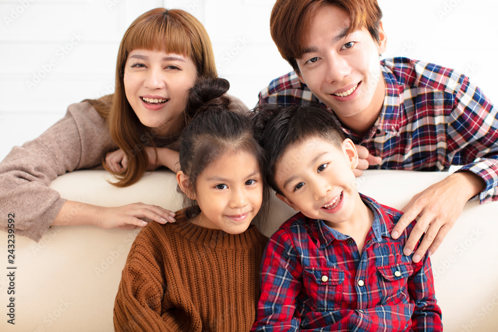 happy asian family sitting on sofa at home happy asian family sitting on sofa at home