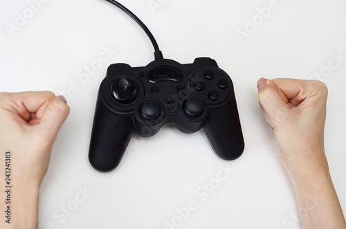 female hands next to game joystick on white background