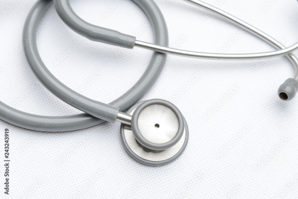 Top view of gray stethoscope medical equipment on white canvas. instruments device for doctor. medicine concept Top view of gray stethoscope medical equipment on white canvas. instruments device for doctor. medicine concept