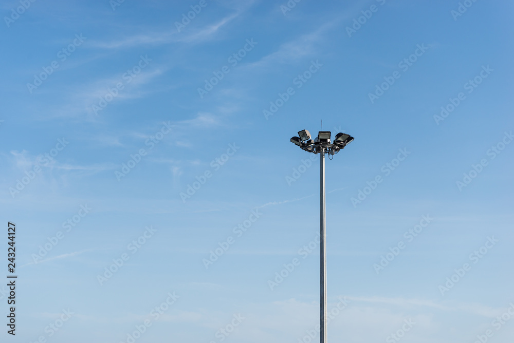 Outdoor spotlight tower with cloud and blue sky in background with copy space