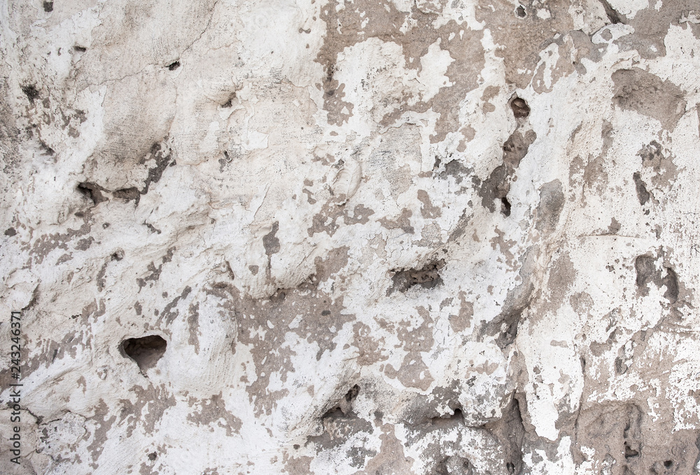 Closeup of beige porous stone textured wall with damaged paint. For background, product designs or skin Closeup of beige porous stone textured wall with damaged paint. For background, product designs or skin