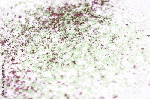 crushed green and purple eye shadow on white background