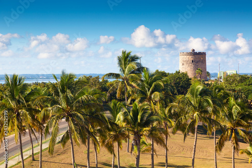 Historical tower in Varadero, Cuba with palms and blue sky.