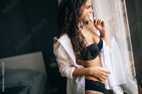 Sensual woman in sexy pose with long natural hair, open shirt and black panties