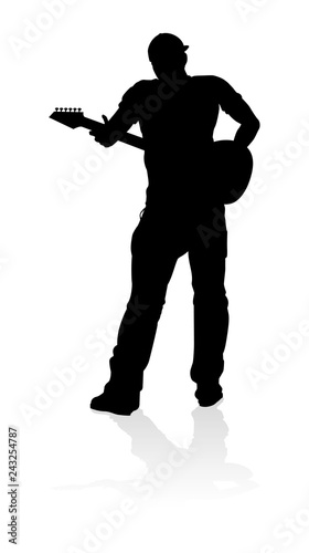 A guitarist musician in detailed silhouette playing his guitar musical instrument.