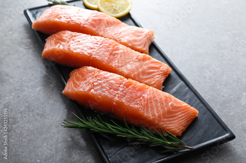 Plate with cut salmon fillet on table