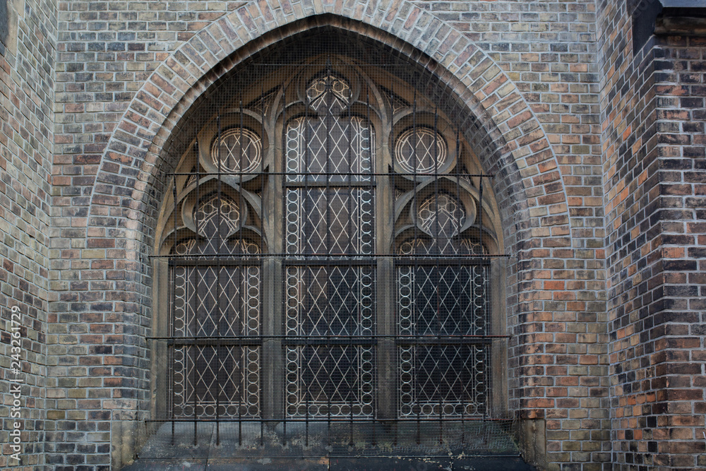 Large arched window at the facade of old catholic church