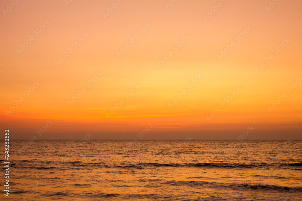 bright yellow gray pink sunset sky over the ocean
