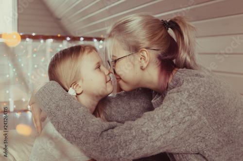 cozy photo session of two beautiful happy sisters in wooden house photo