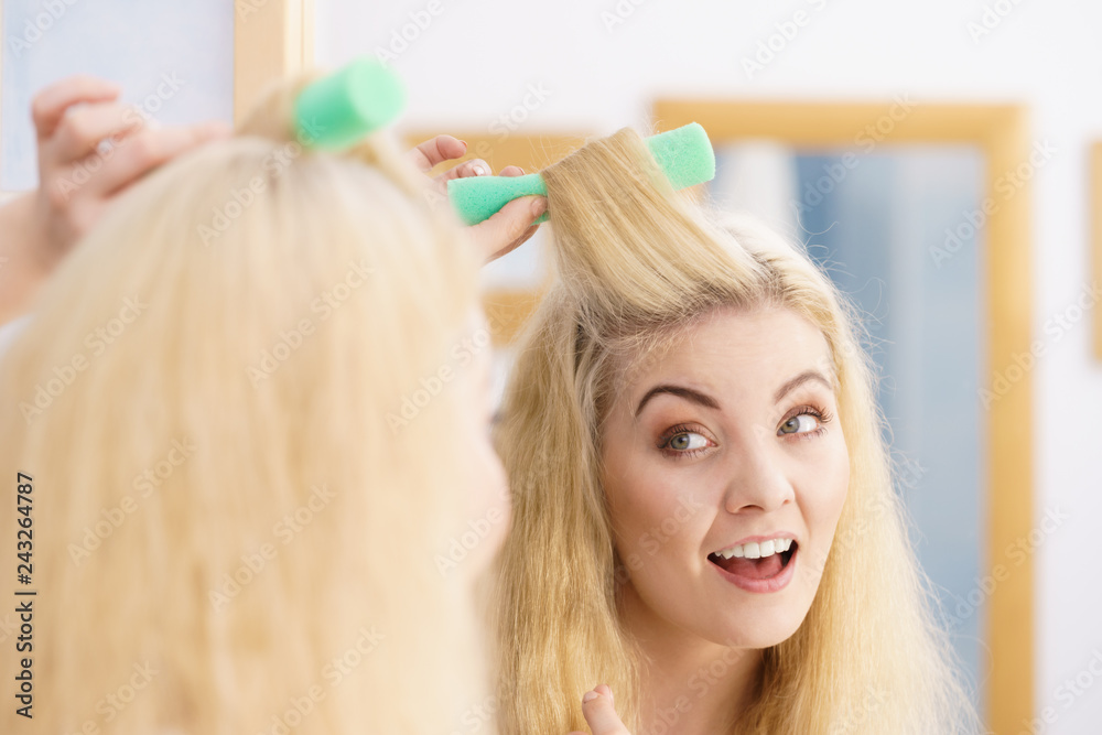 Blonde woman using hair rollers Blonde woman using hair rollers