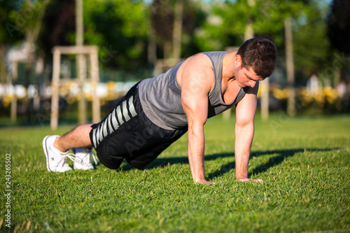 young man doing stretching exercise in the park