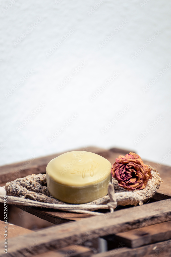 Seifenstück mit Sisalsäckchen und Rosen auf Weinkiste Seifenstück mit Sisalsäckchen und Rosen auf Weinkiste
