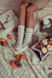 Women's legs in white knitted socks. photo in Hyugge style,