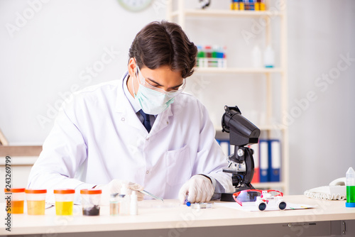 Young handsome chemist working in the lab