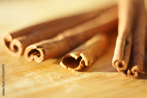 whole cinnamon sticks lie together on a wooden Board in bright sunlight photo