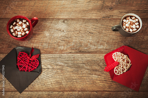 Festive composition on rustic wood table, red and gray mug with marshmallows or cocoa, hearts in envelopes, dried rose flowers. Copy space. Birthday, Valentines, Women's, Wedding Day concept