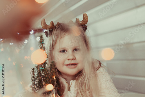 Portrait of happy girl with deer horns on her head photo