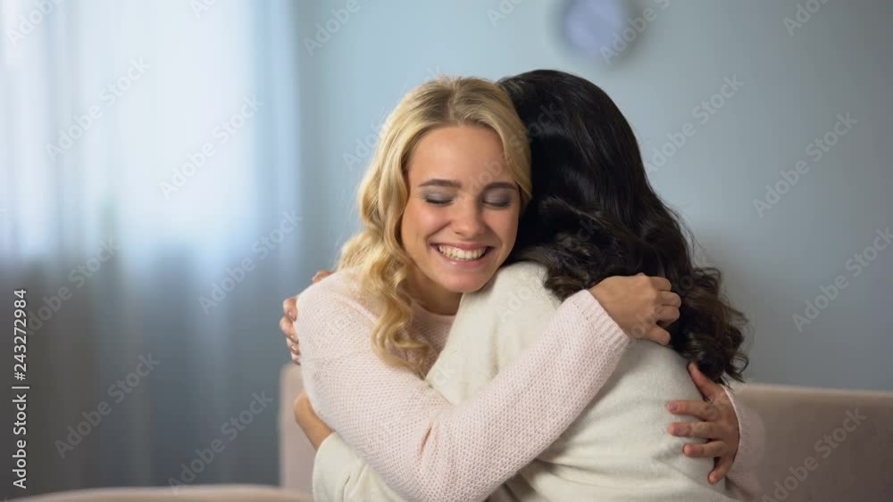 Women sitting at home, happily smiling and hugging, good news, friendship Women sitting at home, happily smiling and hugging, good news, friendship
