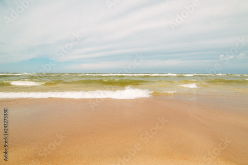 Endless beach scene, calm summer landscape of nature. Blue sky and soft ocean waves. White sand on the seashore