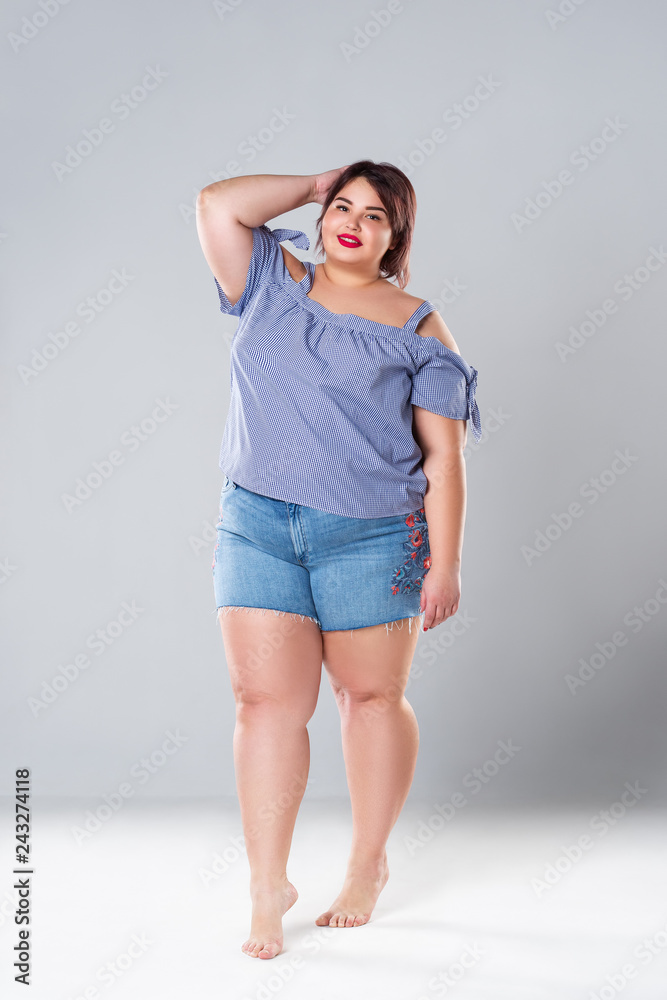 Plus size fashion model in jean shorts, fat woman on gray background Stock  Photo | Adobe Stock