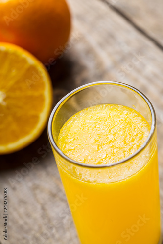 Orange juice and orange slices on wooden table