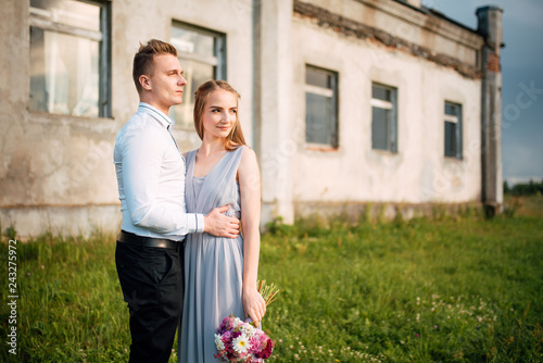Young cute bride with bouquet of flowers hugging the groom on nature. Beautiful wedding couple outdoor portrait. Portrait of a loving couple. Wedding photo session. Second half. Newlywed © Pavel
