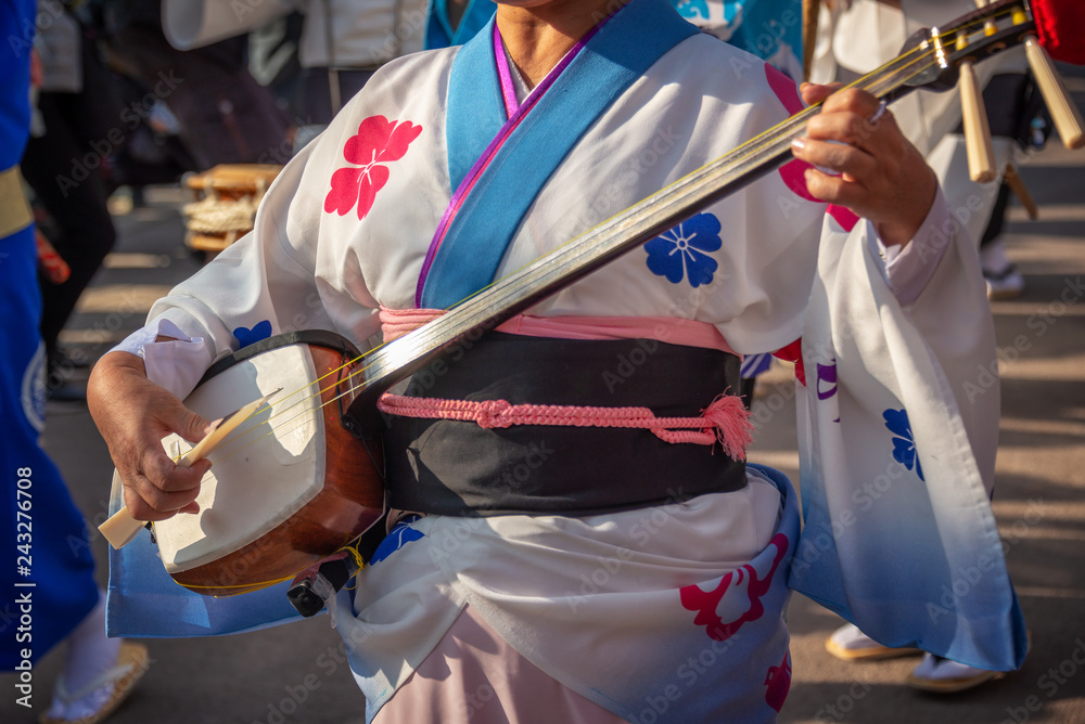 Naklejka premium Kobieta bawić się shamisen na Awa Odori tradycyjnym japońskim tanu festiwalu