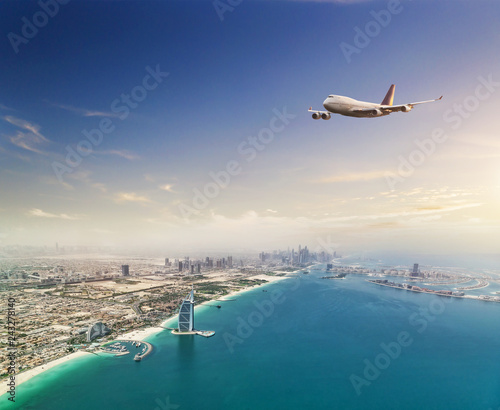 Commercial airplane flying above Dubai city