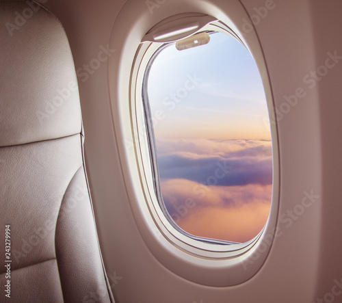 Fototapeta Samolotowy wnętrze z nadokiennym widokiem zmierzch nad chmury.