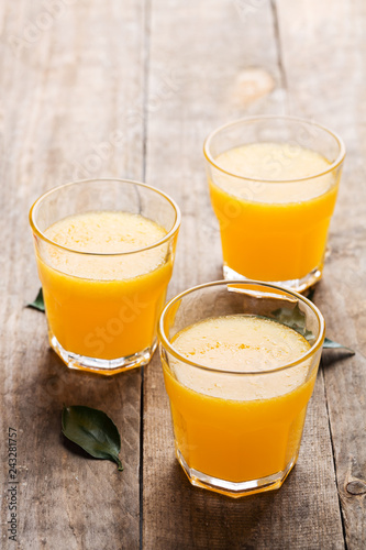 Freshly pressed orange juice, surrounded by fresh oranges