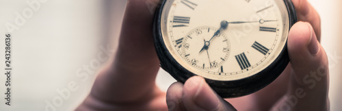 Time goes by: Man is holding a vintage watch in his hand, business context, copy space