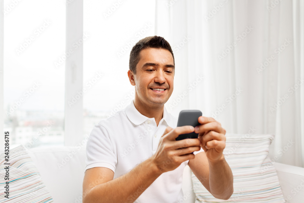 technology, people and communication concept - happy man with smartphone at home technology, people and communication concept - happy man with smartphone at home