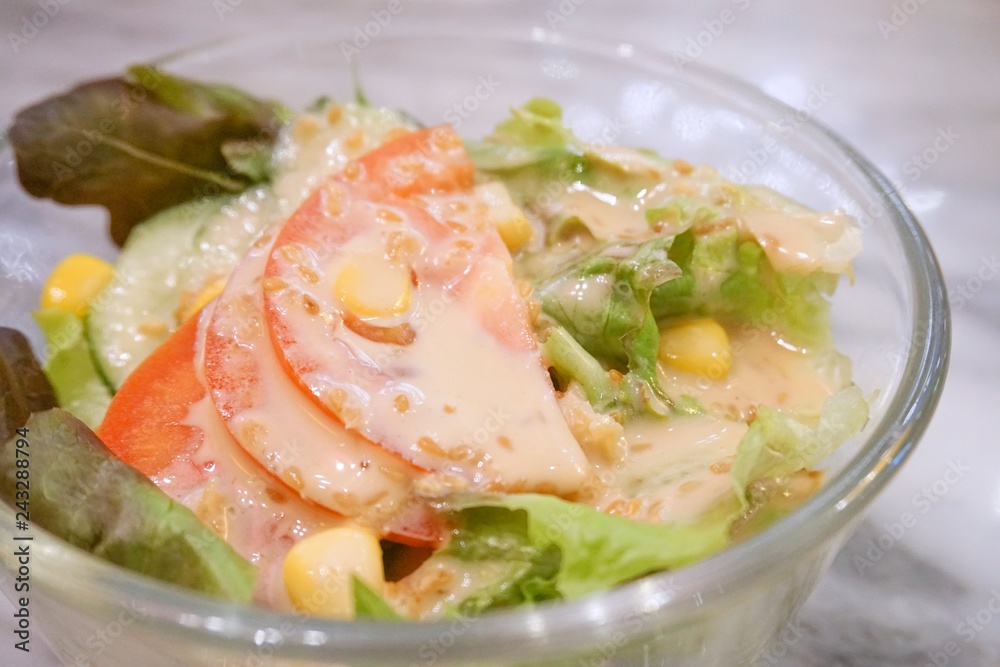 A bowl of fresh tomatoes, lettuce, cucumber and sweet corn Japanese salad with sesame dressing. A bowl of fresh tomatoes, lettuce, cucumber and sweet corn Japanese salad with sesame dressing.