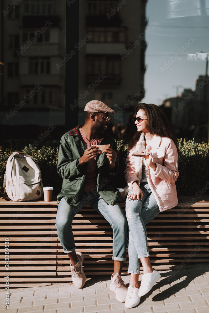 Young beloved couple sit on wooden balustrade Young beloved couple sit on wooden balustrade