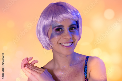 Carnaval Brazil. EFace of brazilian girl wearing purple wig and makeup mask. Colorful background. Carnival concept, fun and party. photo